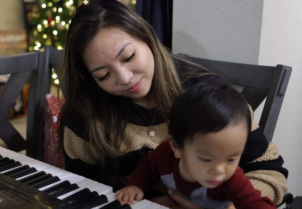 Playing keyboard at home with her son on her lap