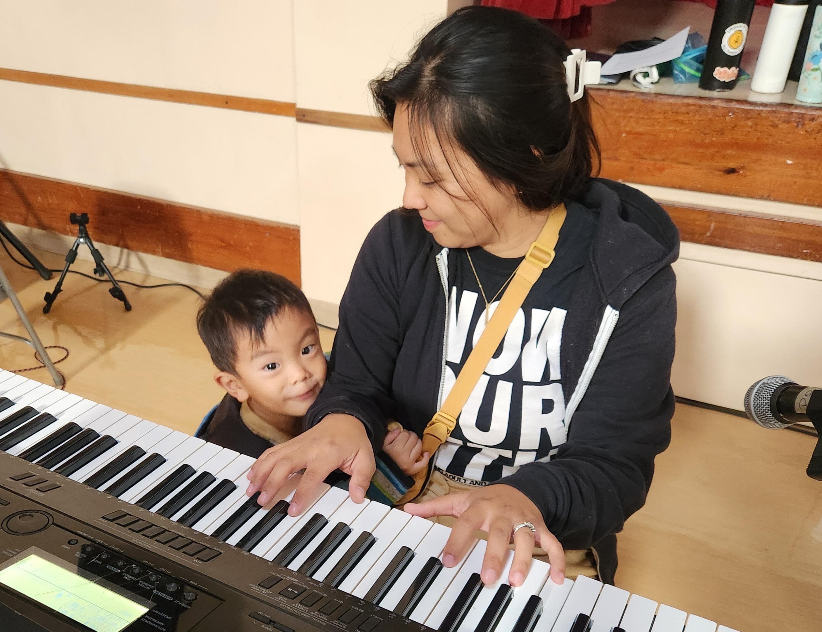 Rehearsing at the parish hall while her son looks on