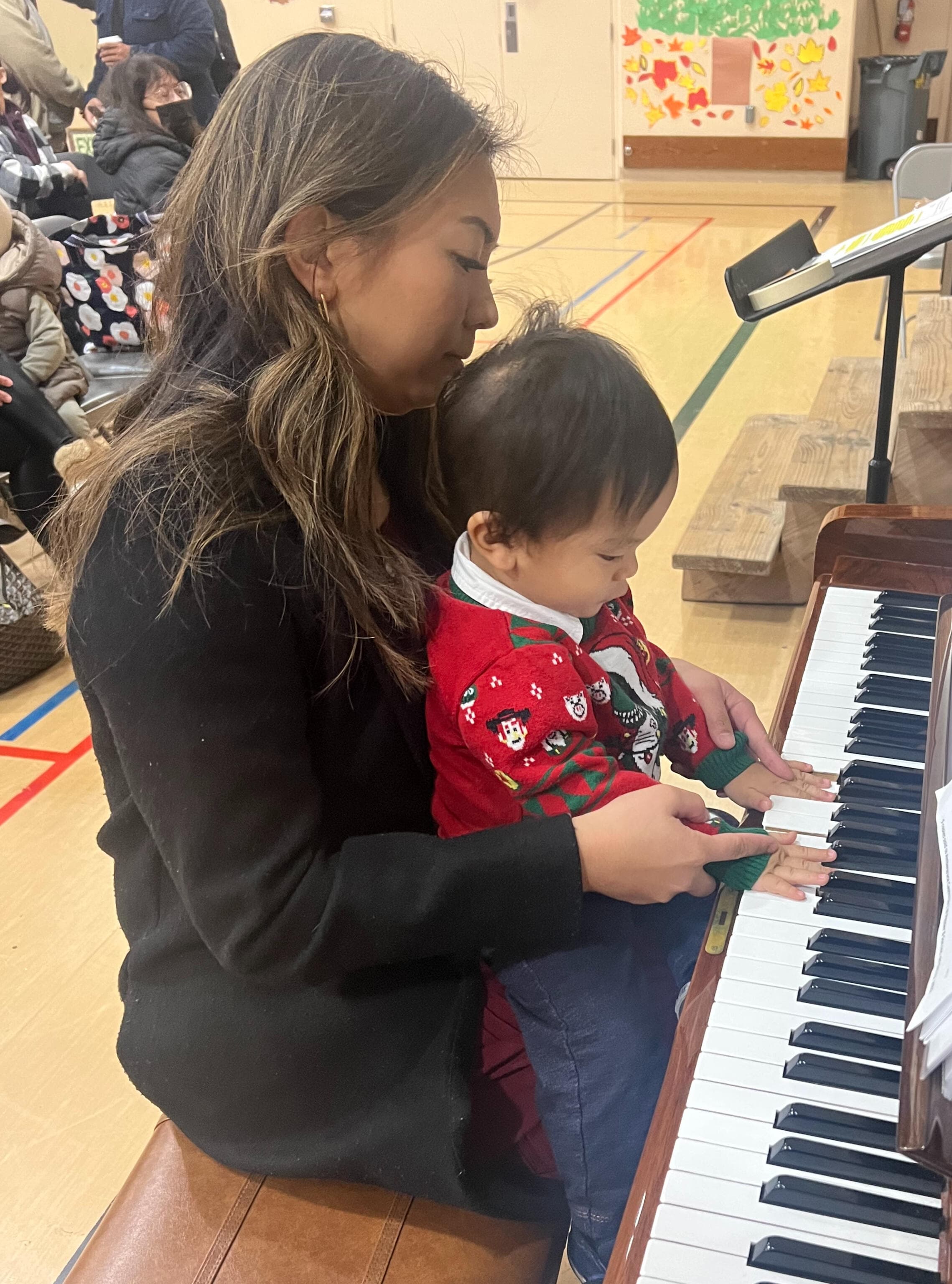 At the piano with her son at a school Christmas program